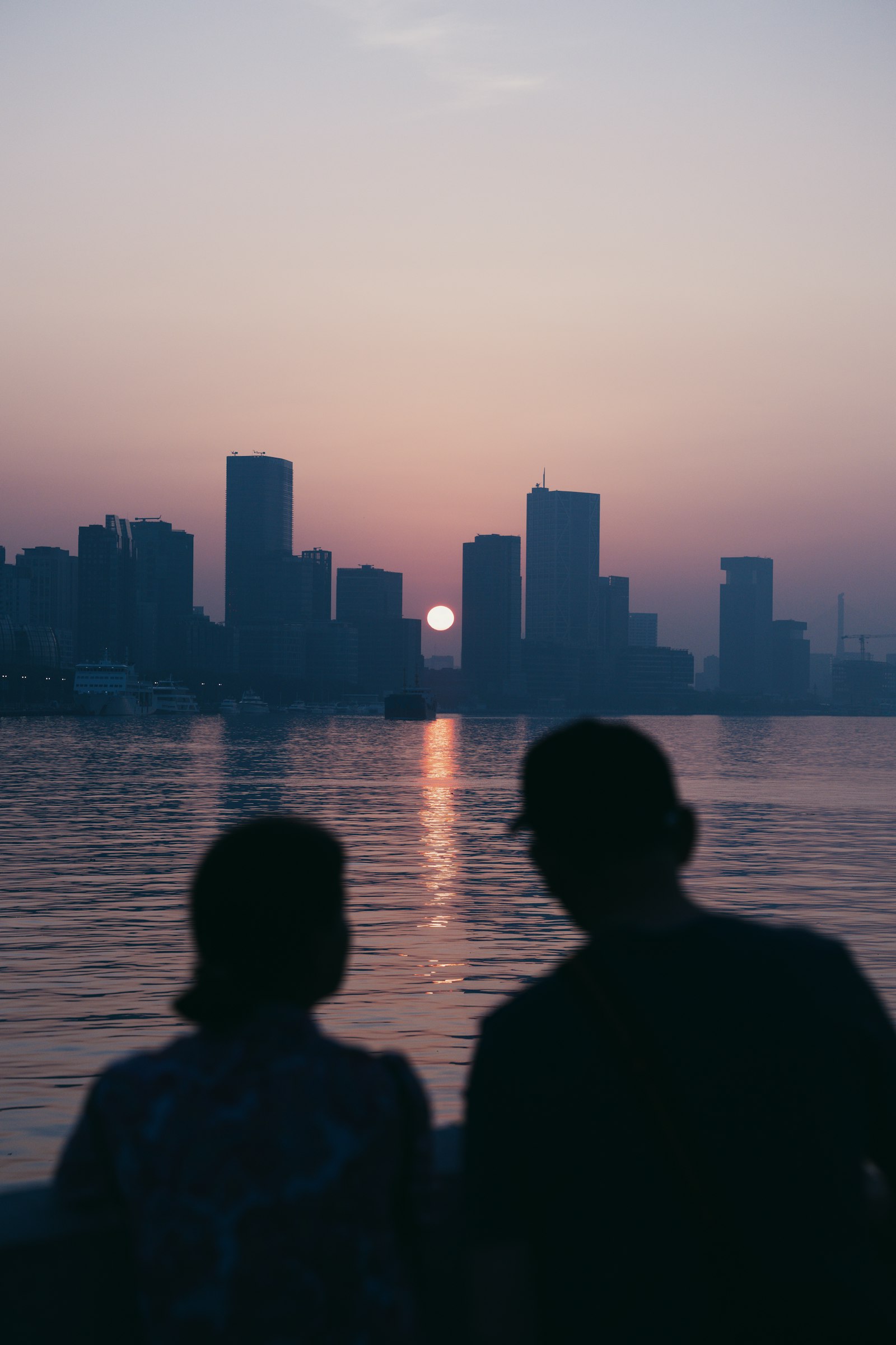A couple watching the sunset over a city skyline