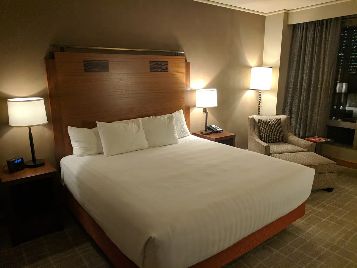 A made bed in a warmly lit hotel room