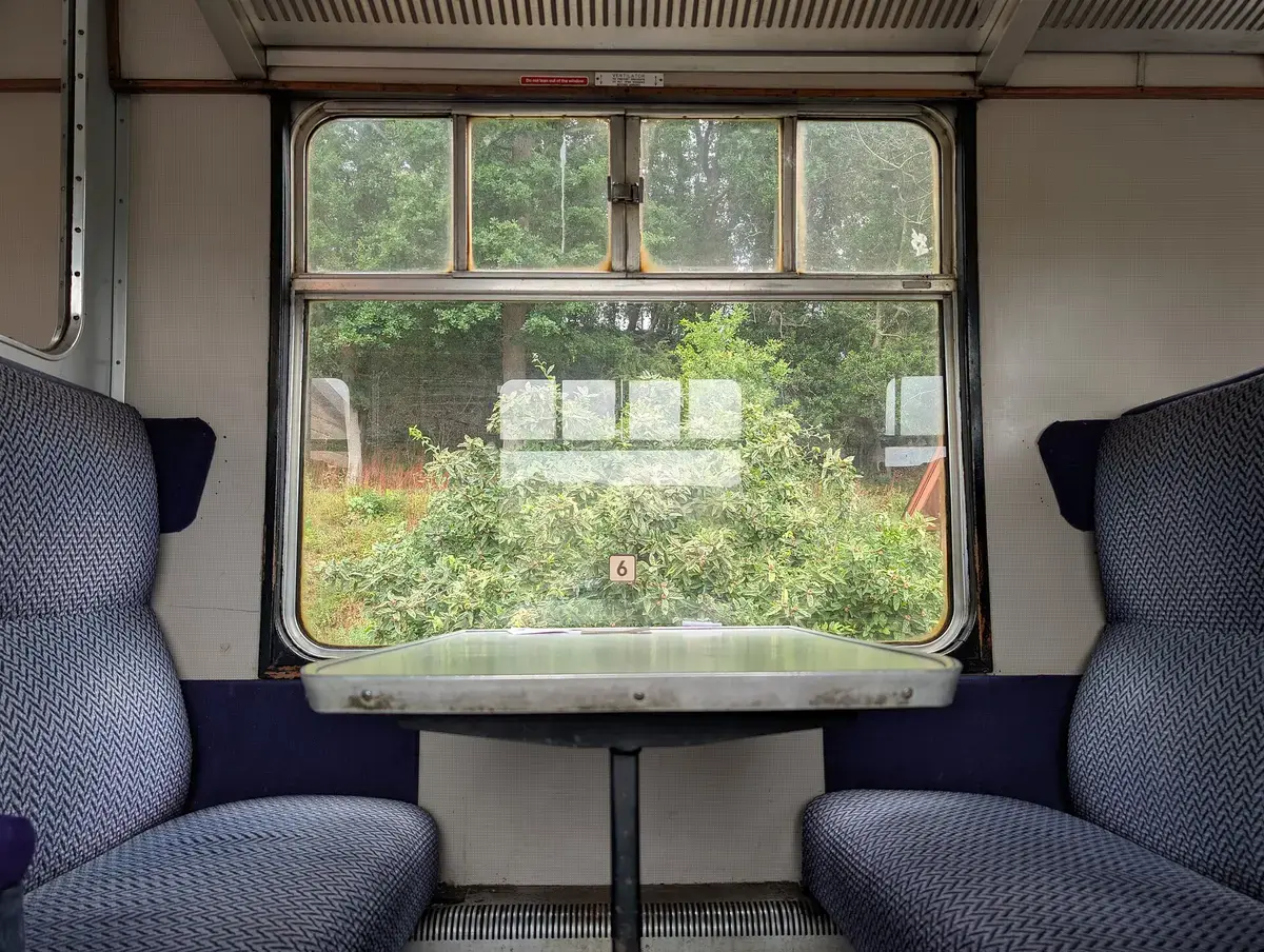 Two seats facing each other by a train window